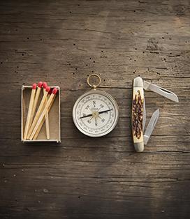 Matches, compass, and pocket knife on a table