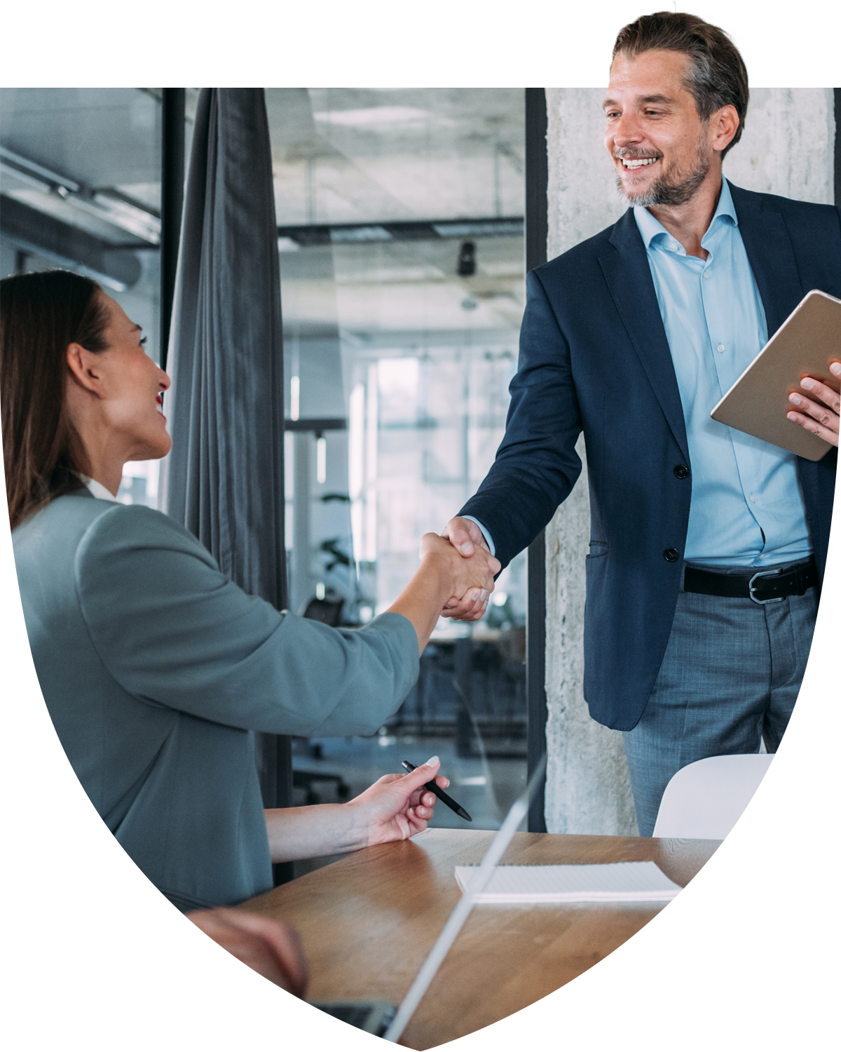 Professional man and woman greeting each other with handshake in the office