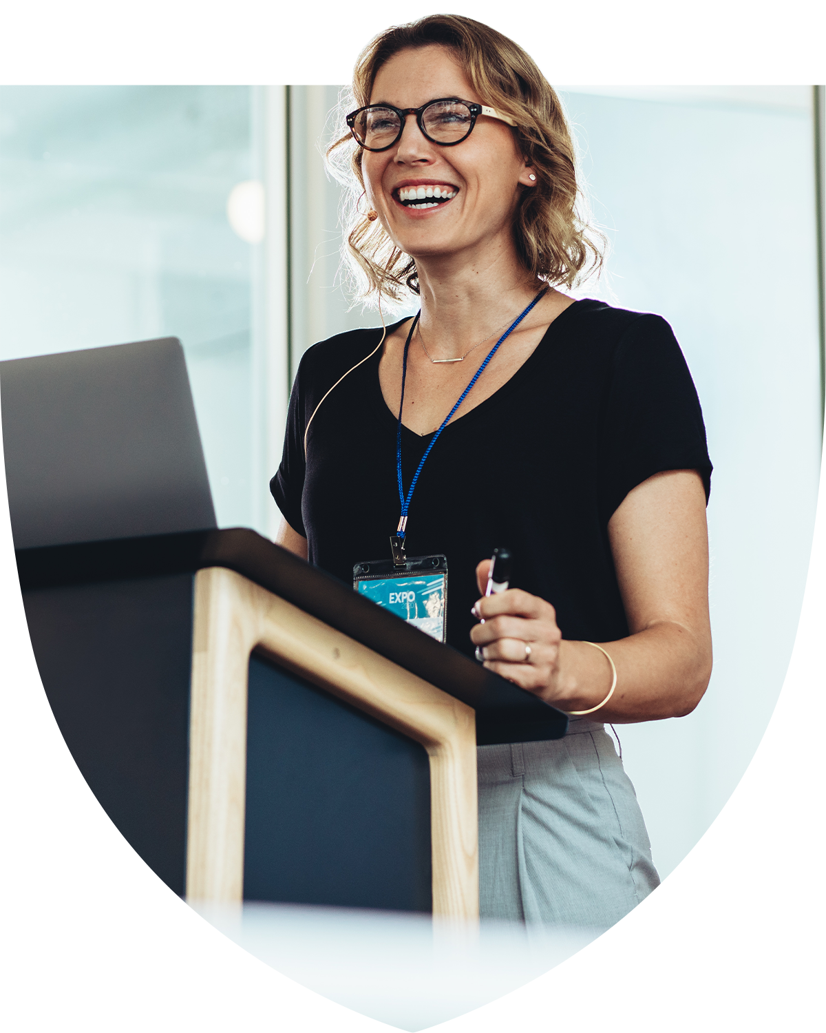 Happy businesswoman standing at the podium presenting to crowd