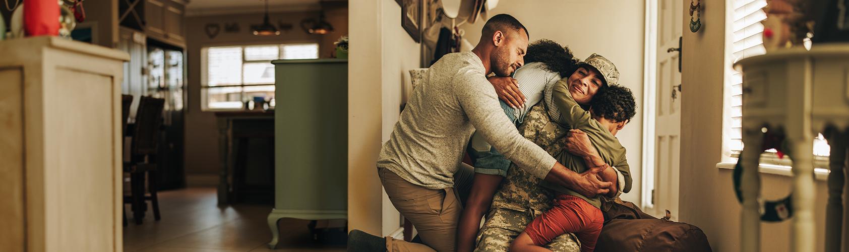 Military family hugging each other at the door