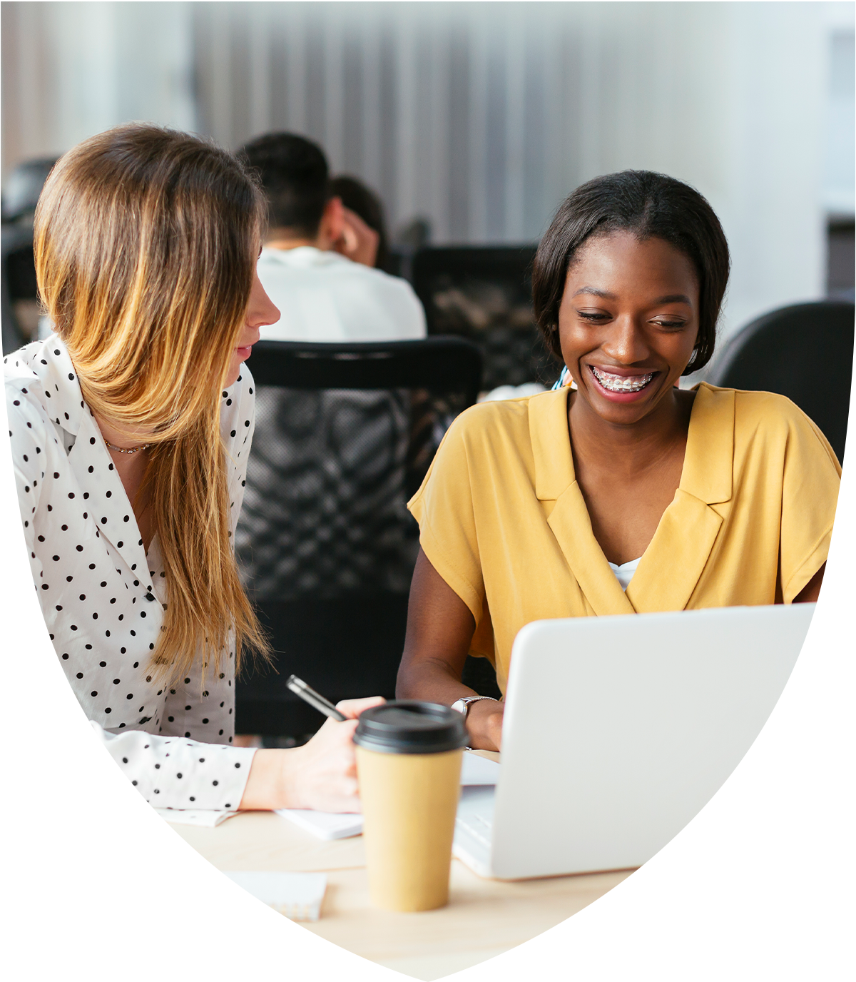 Two women talking while looking at a laptop