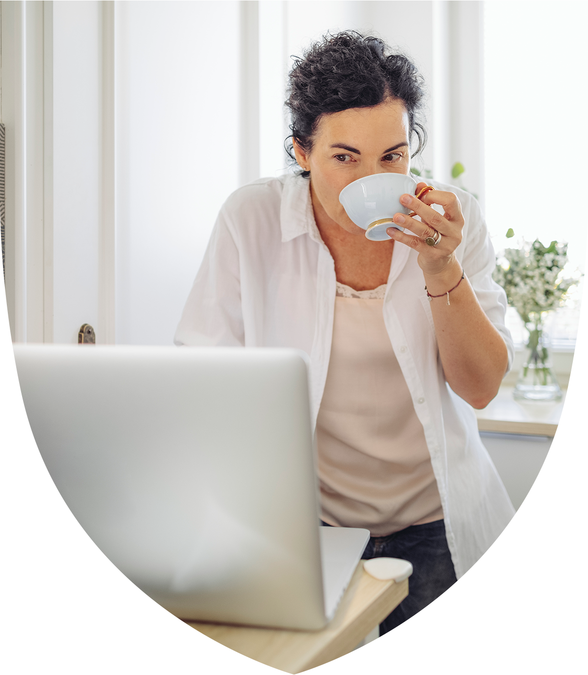 Woman drinking tea at a laptop