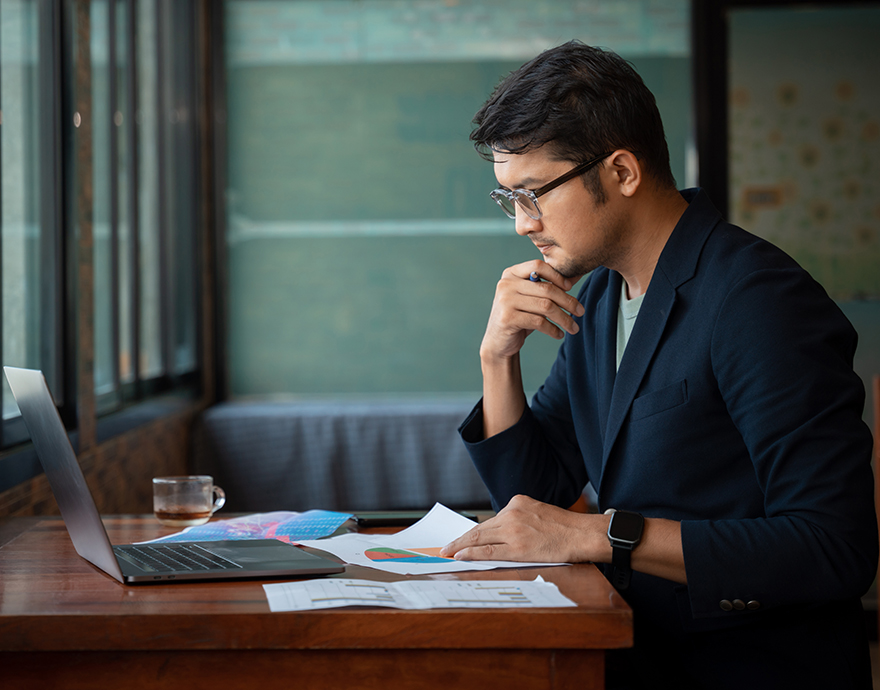 Man working at a desk with a laptop and papers
