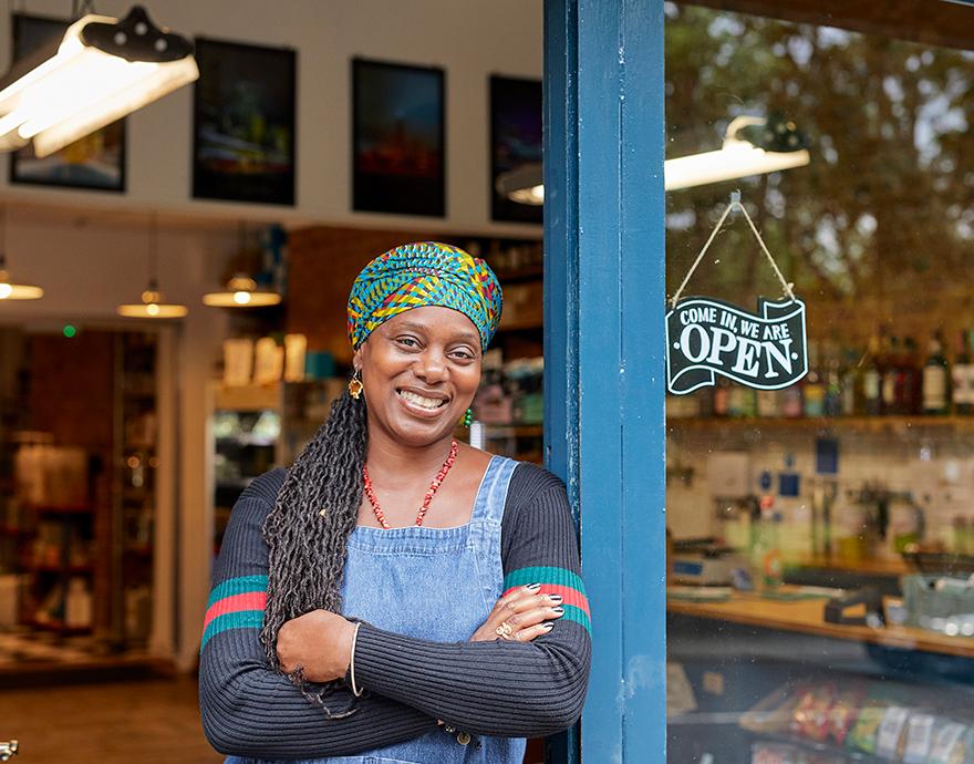 Woman leaning on an open shop door