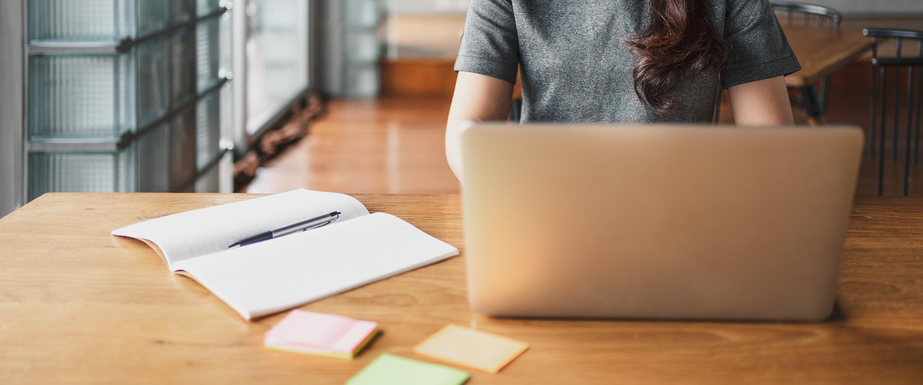 Laptop on desk with papers
