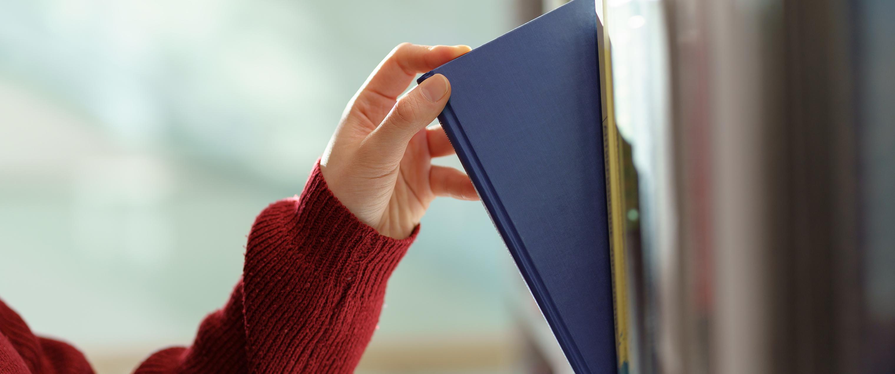 Woman reaching for a book in the library