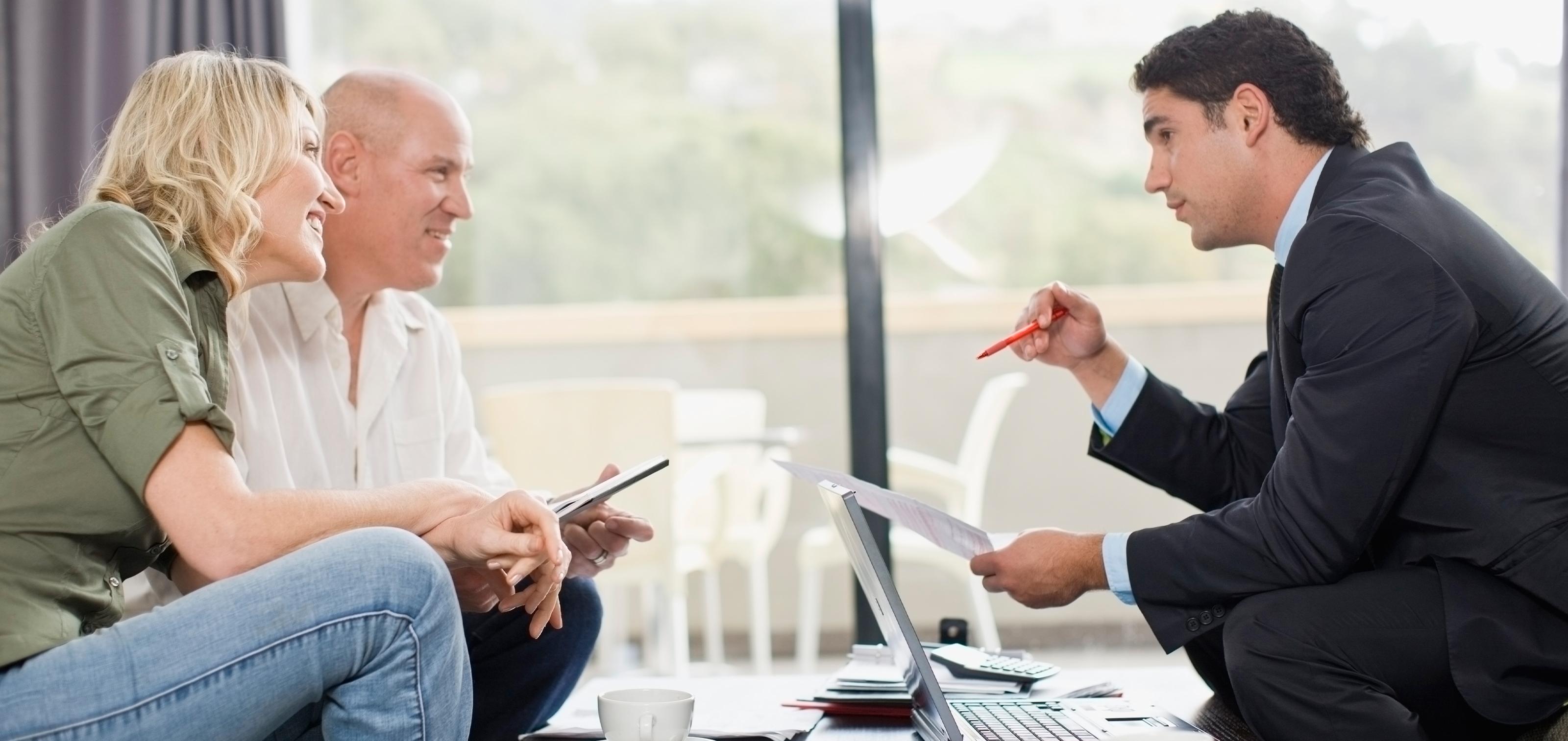A couple talking to a man across the table 