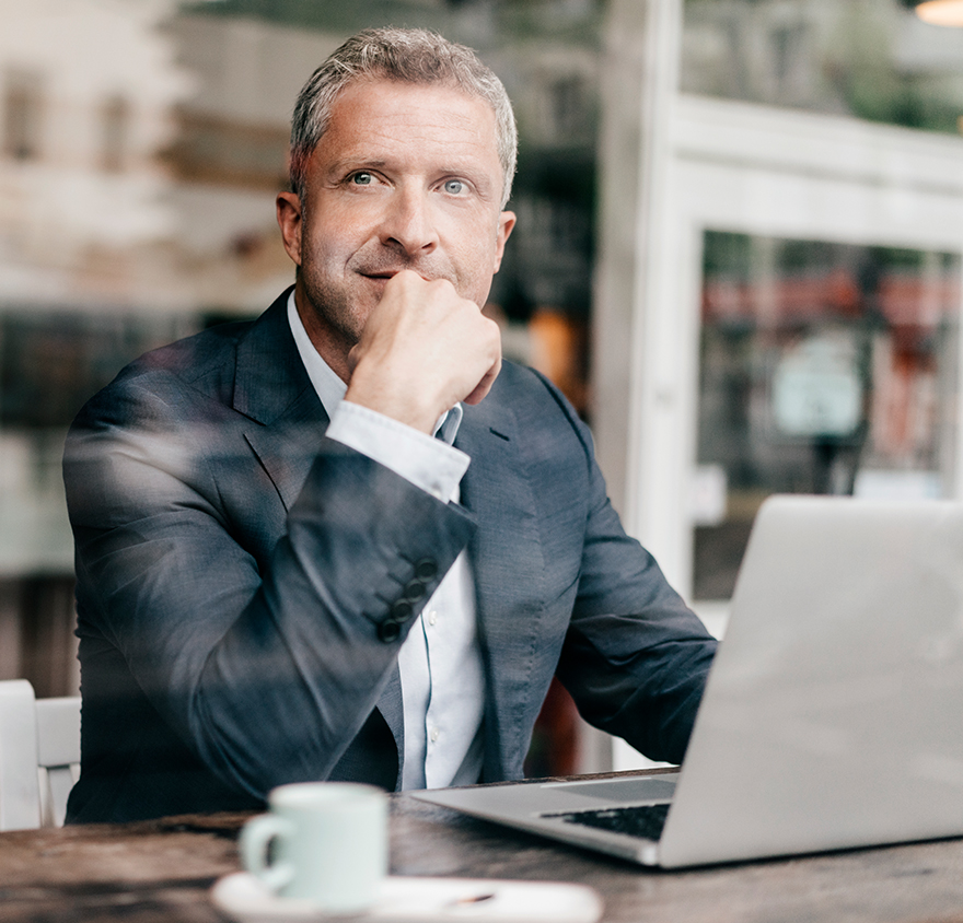 Man looking up while working at laptop
