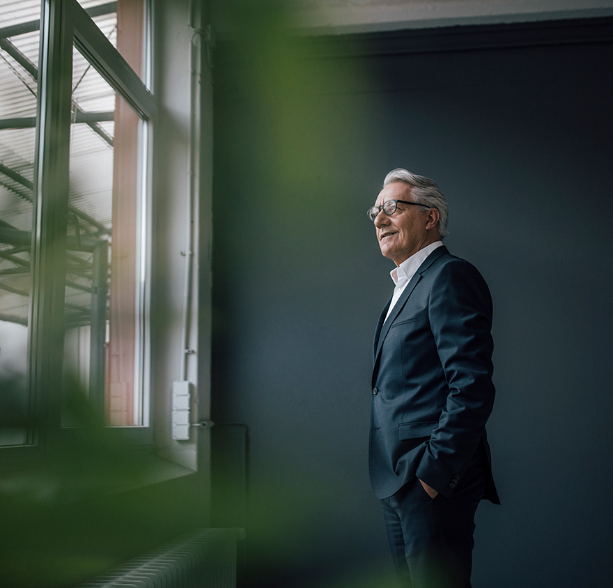 Man in a suit looking out a window