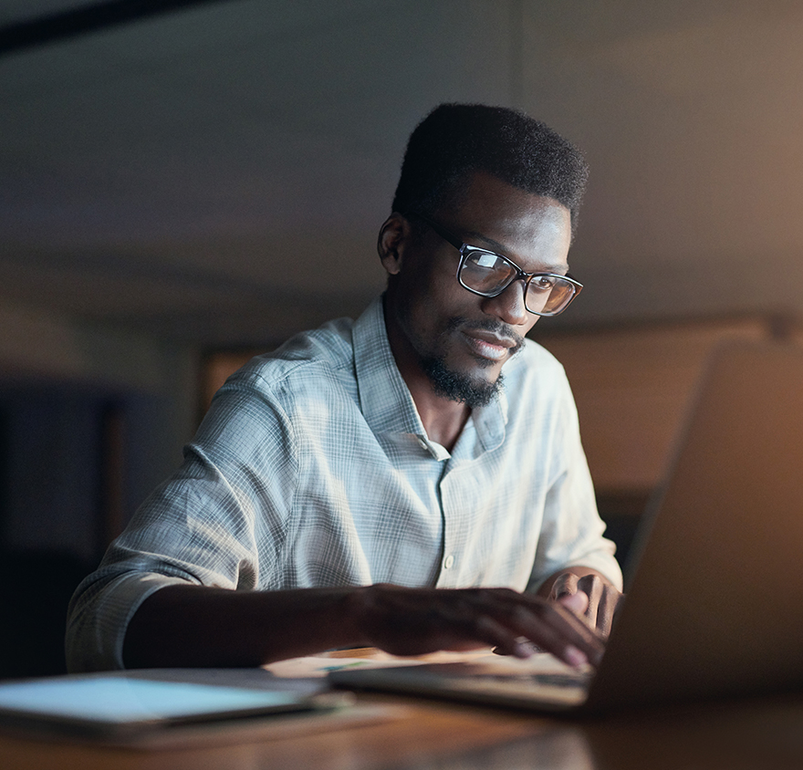 Image of a man working at a laptop