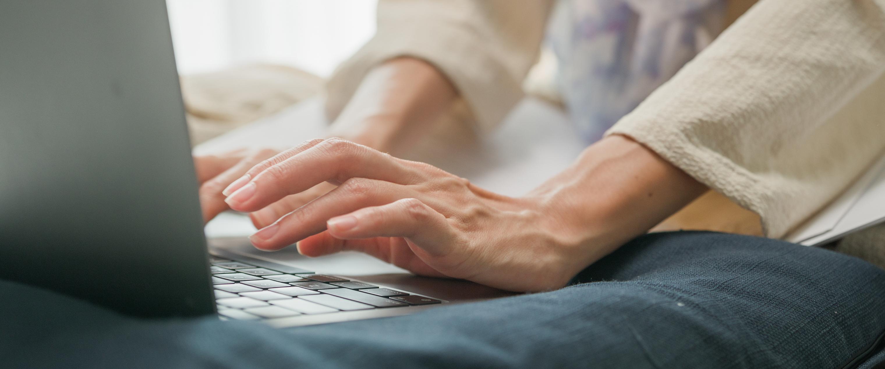 Close up of hands working on a laptop