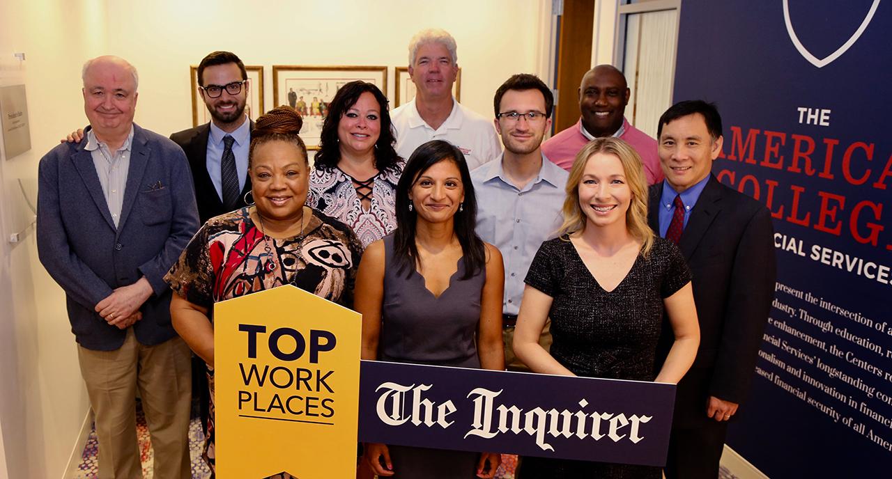 TAC staff holding top work places sign
