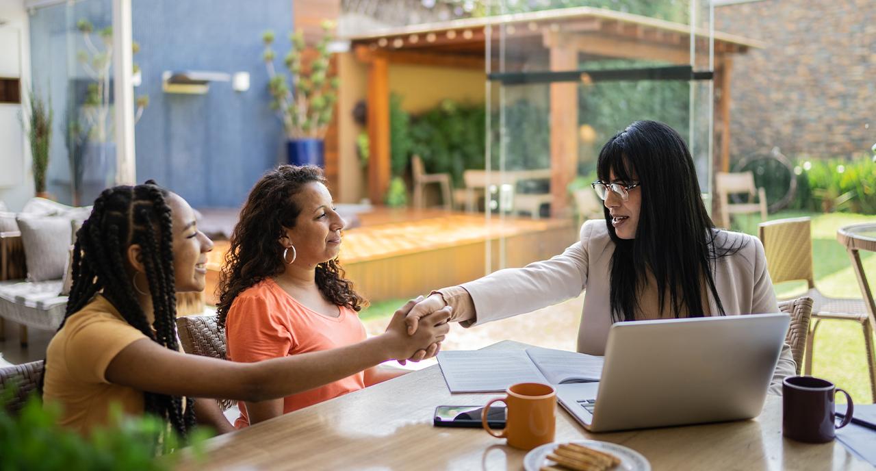 Mother and daughter shaking hands with trustworthy financial advisor