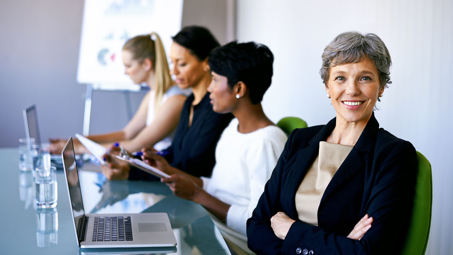 A group of women preparing for a meeting in the conference room