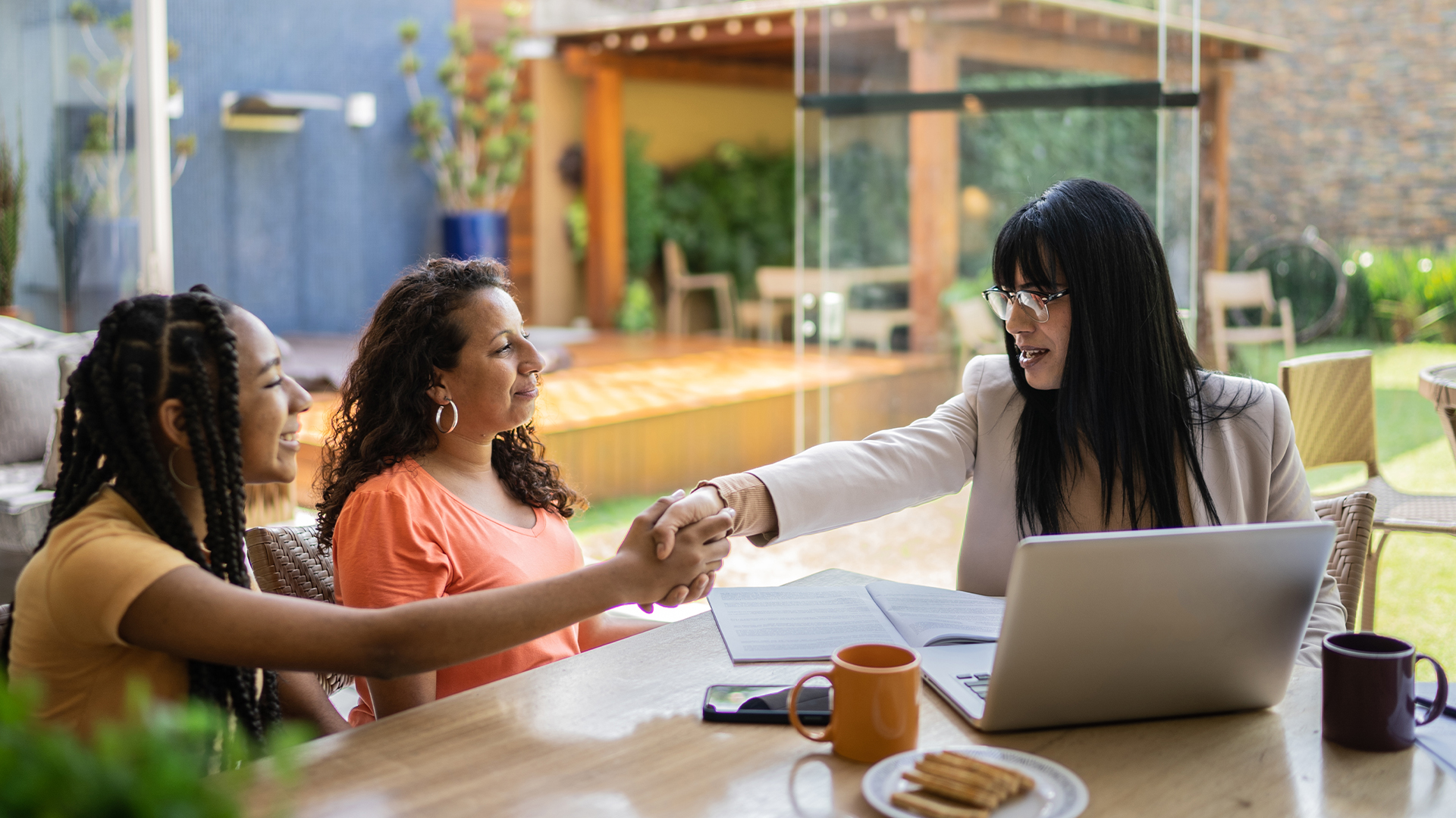 Mother and daughter shaking hands with trustworthy financial advisor
