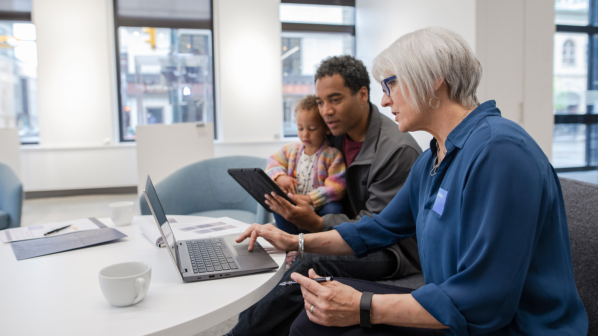 Advisor helping client and his child on the computer