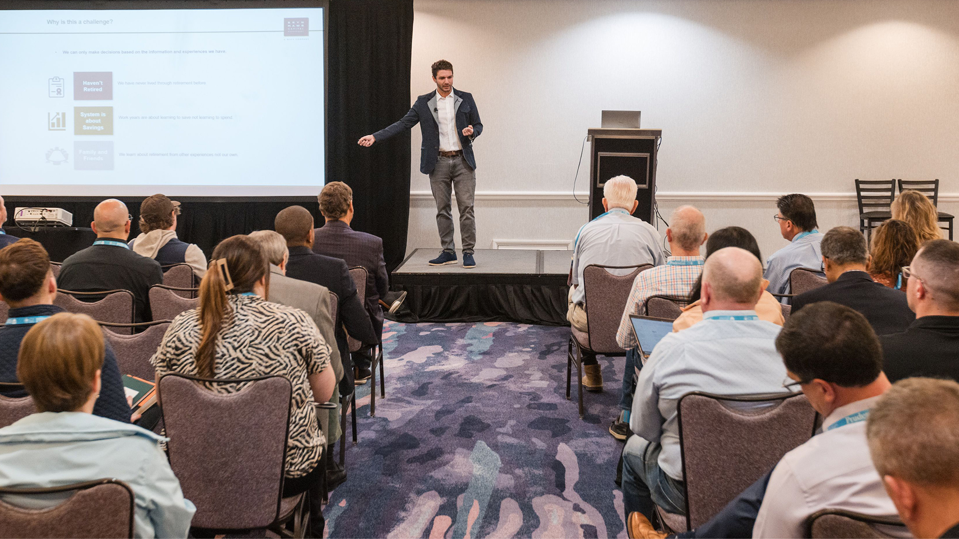 Jamie Hopkins speaking on stage at an event
