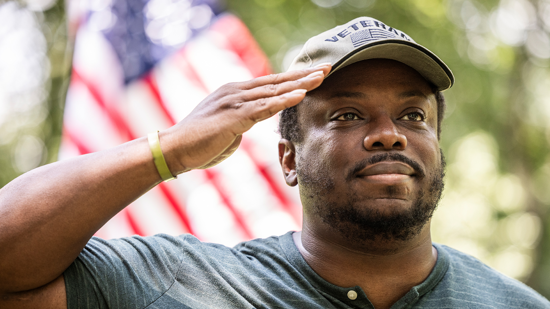 Military Veteran giving a salute in front of the American flag
