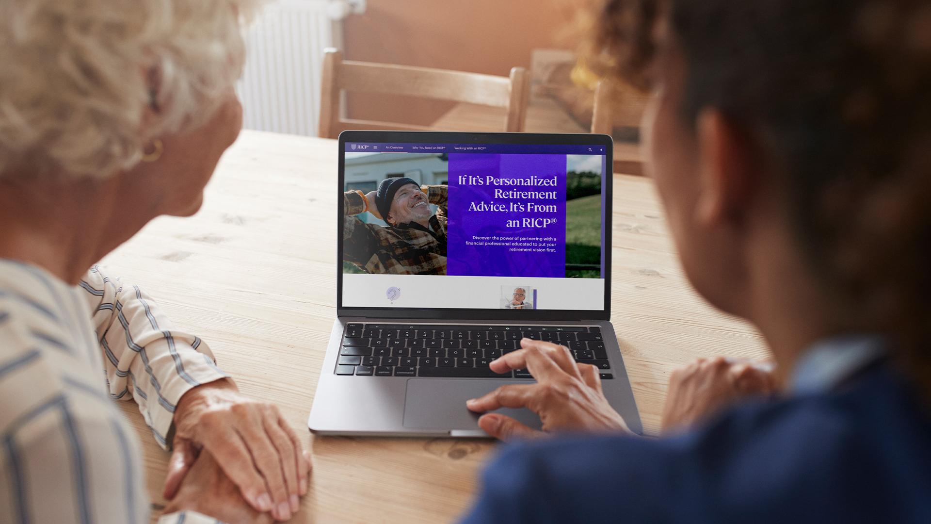 Young man showing older women how to use her laptop