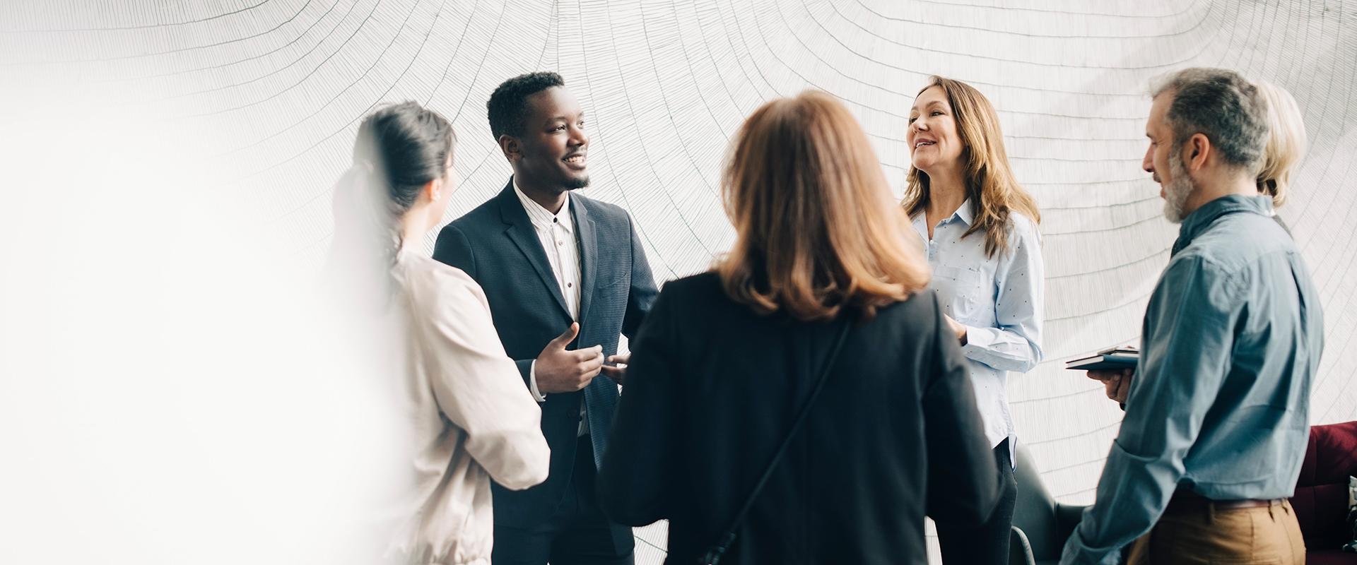 Diverse group of colleagues speaking together in a circle