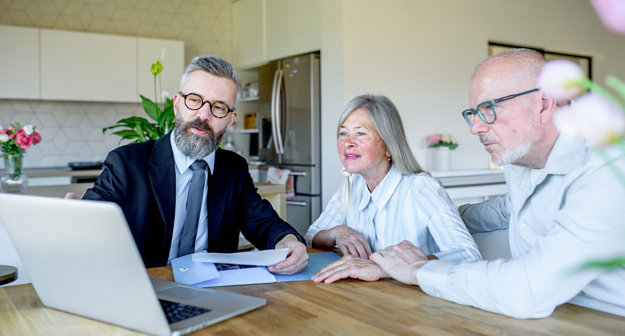 Middle aged advisor meeting with retiree couple