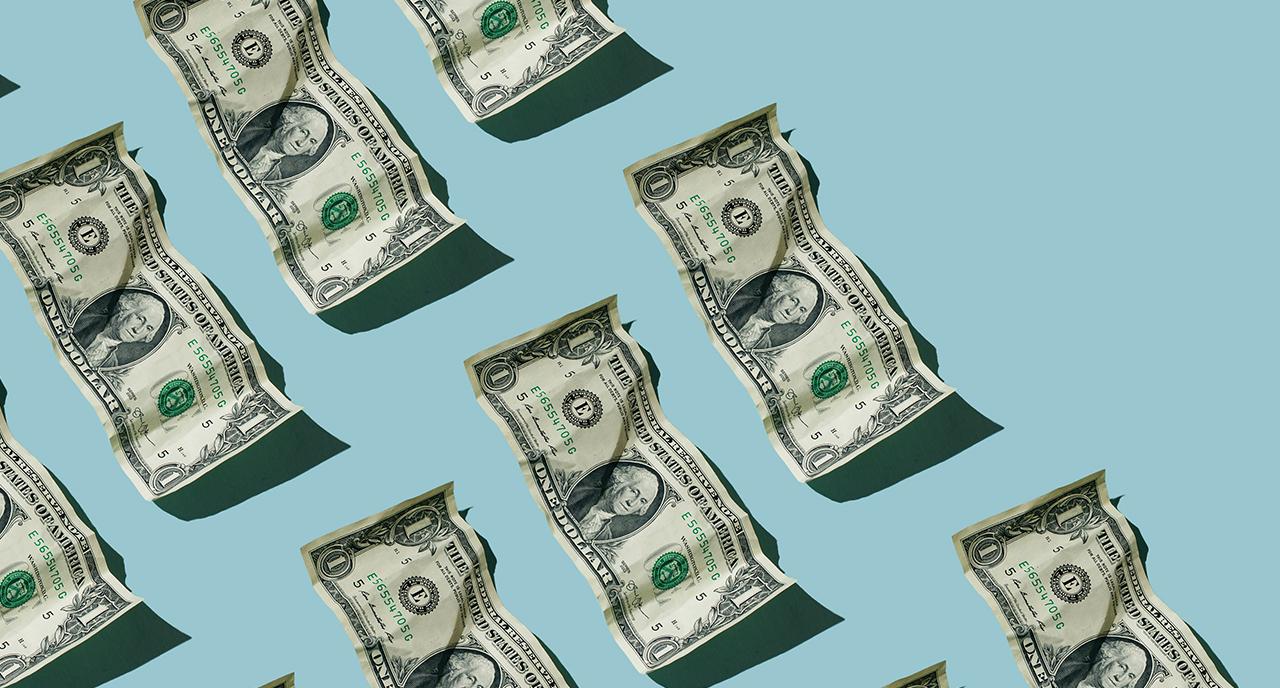Wrinkled one dollar bills stacked in rows