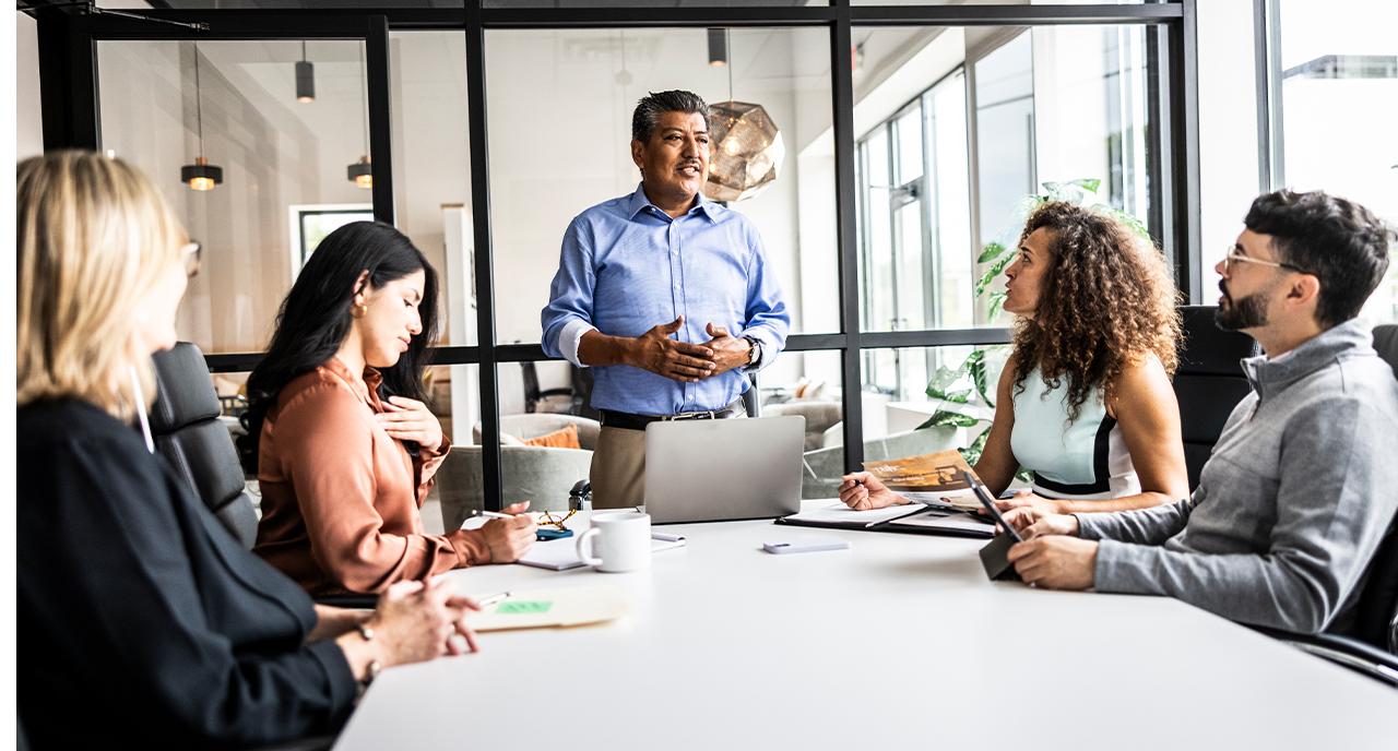 Middle aged man presenting in a meeting at the office