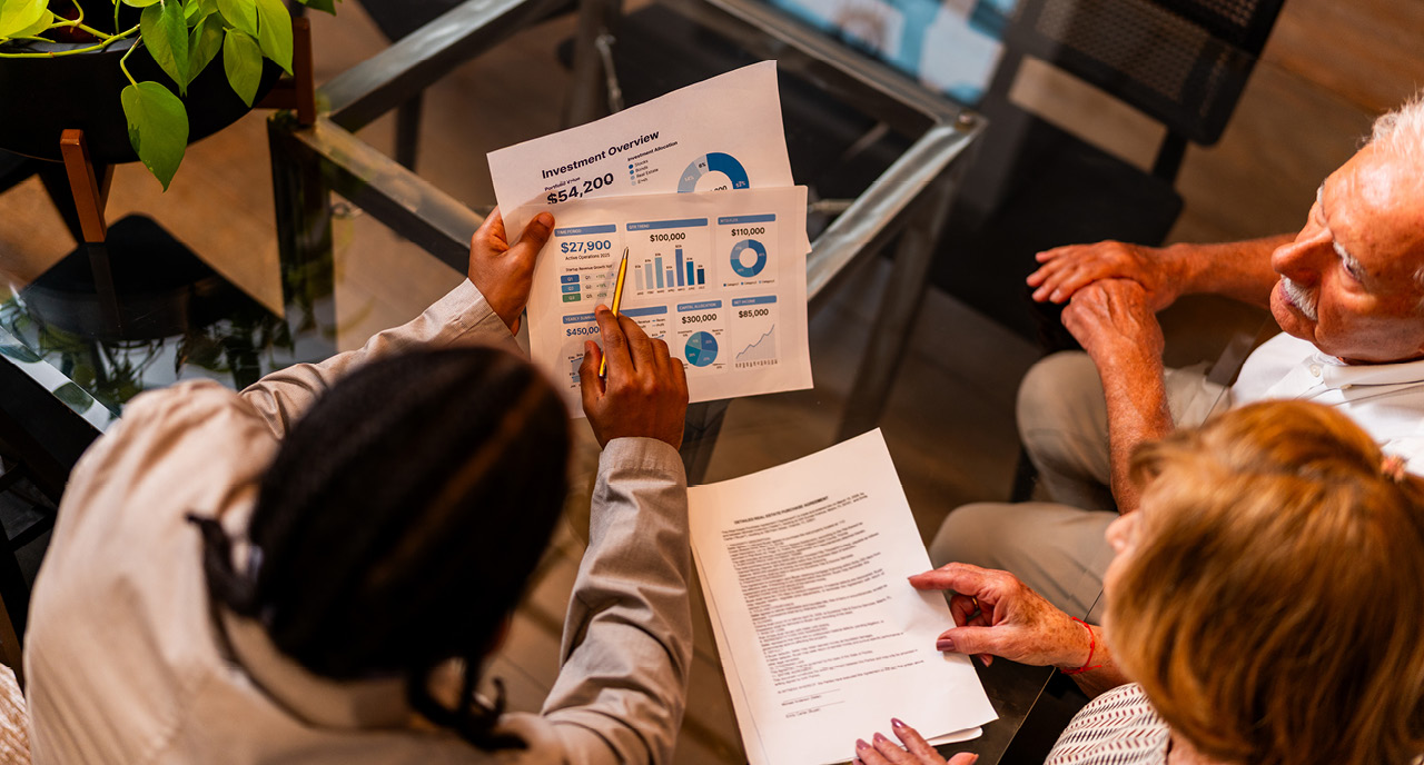 Financial advisor reviewing documents with elderly clients