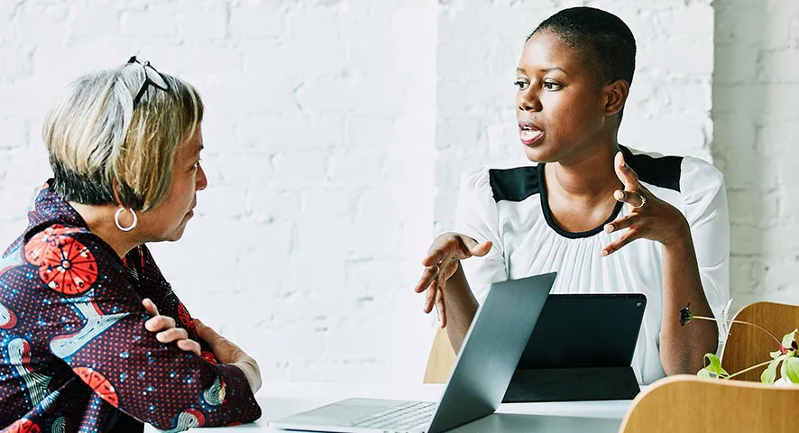 Younger female advisor speaking with an elderly female client
