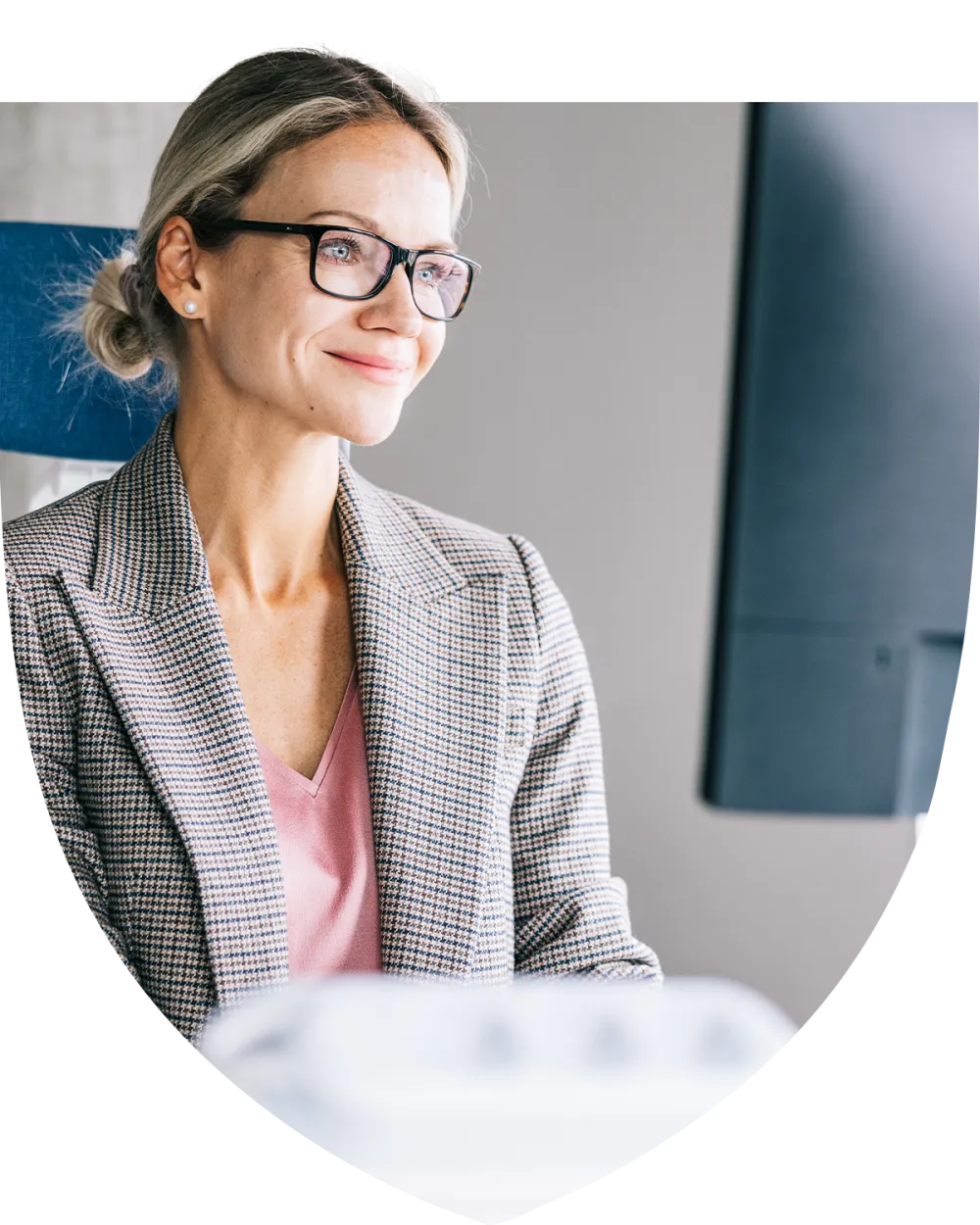 Woman in glasses and suit jacket smiling