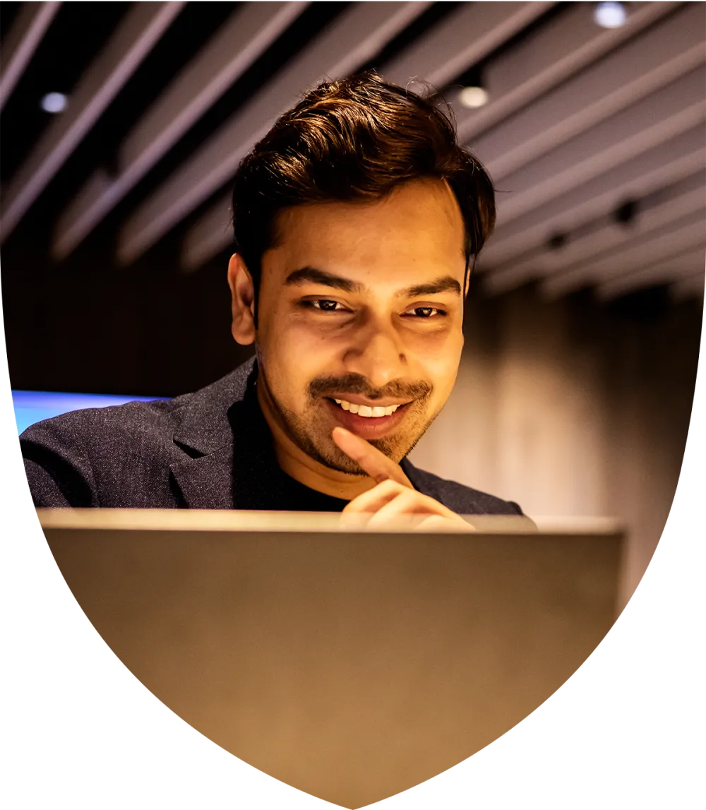 Young male professional smiling while on his laptop