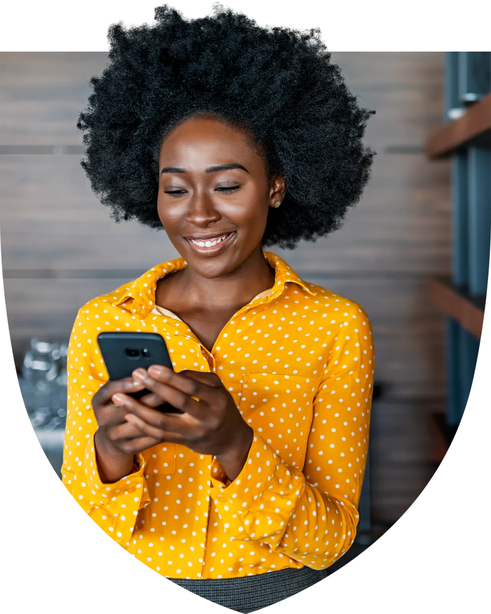Woman in yellow shirt texting on her phone