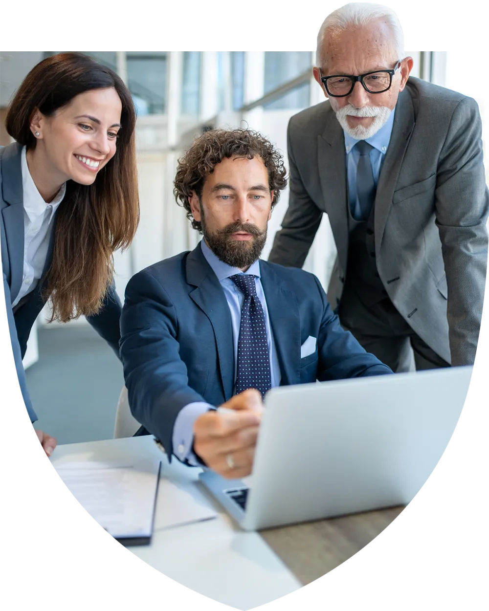 Group of coworkers standing around a laptop