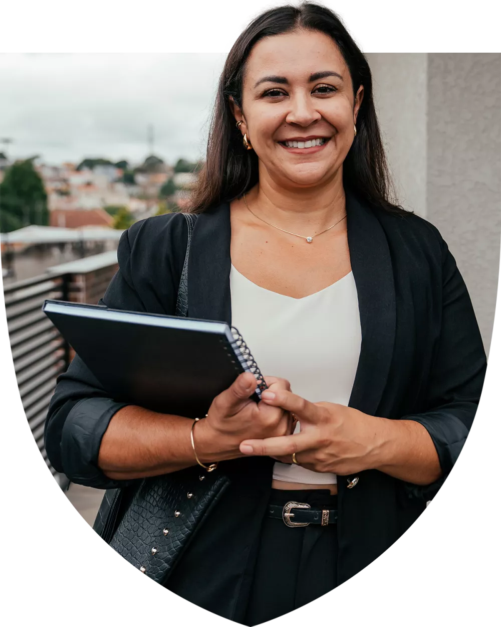 Latina woman smiling with notebook in her hand