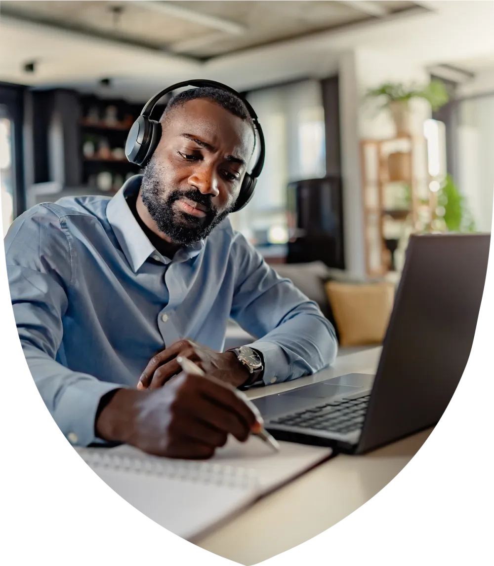 Man with headphones on studying at his desk