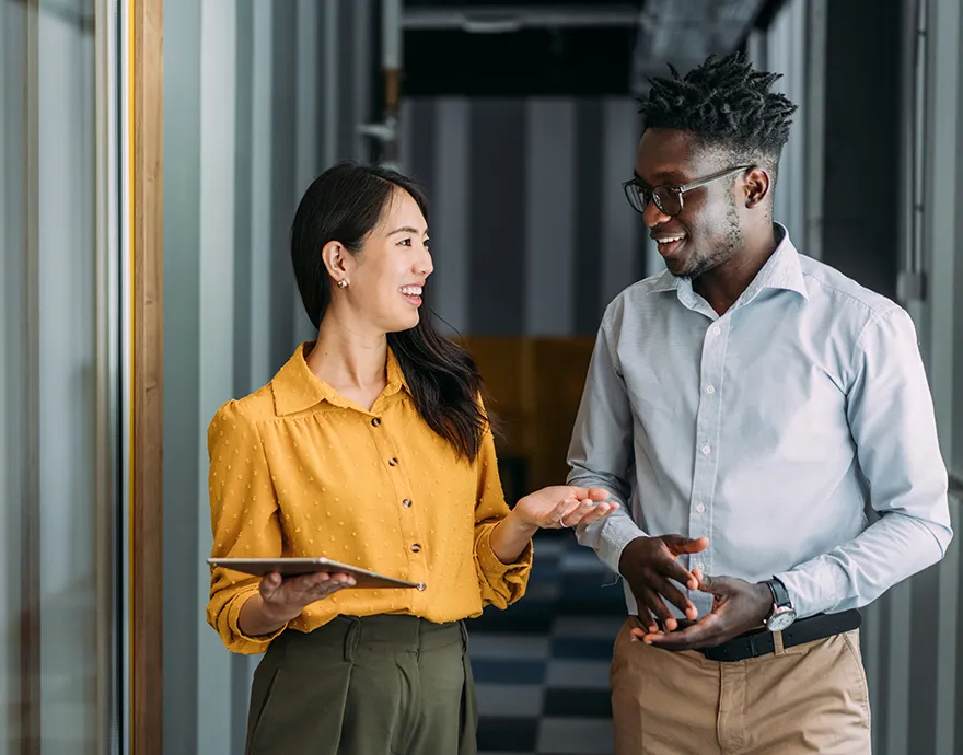 Female and male colleagues speaking together in the office