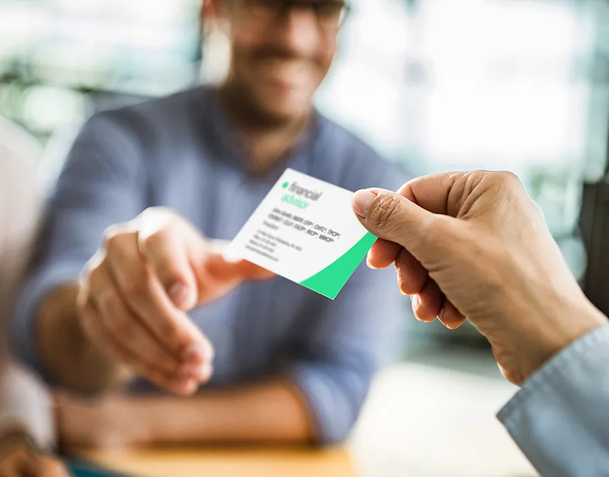 Woman handing a middle aged man a business card