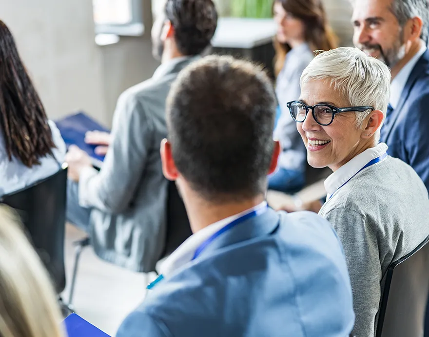 Older woman smiling and talking to young male professional