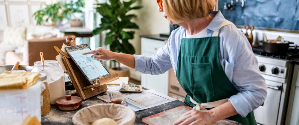 Elderly woman baking and looking at a recipe