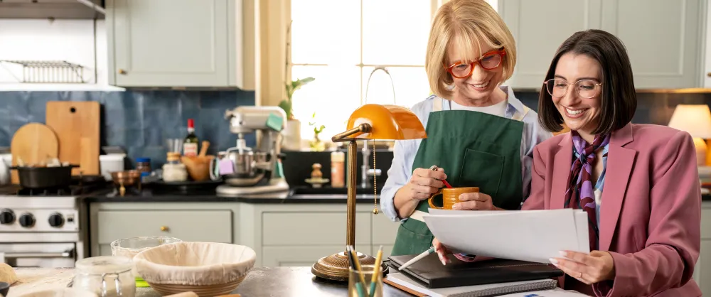 Female advisor and her elder client talking in the kitchen