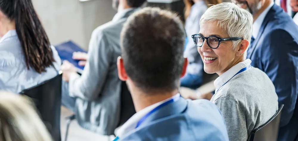 Older woman smiling and talking to young male professional