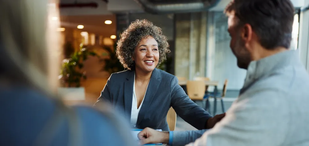 Female financial planner speaking with her clients and smiling