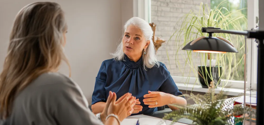 Elderly woman speaking with middle aged woman