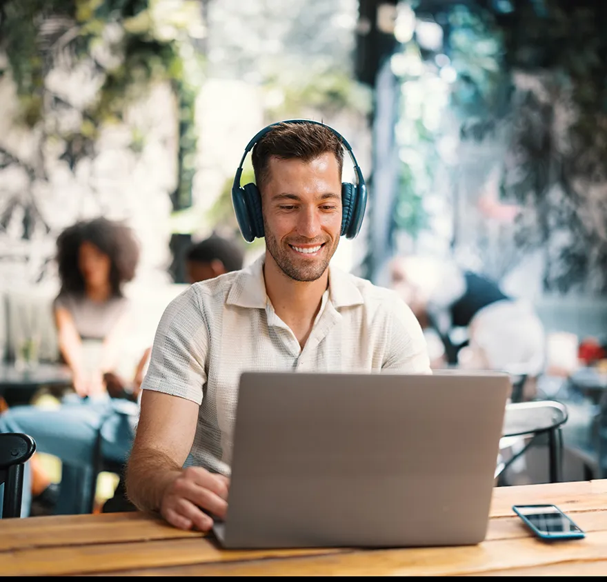 Middle aged man wearing headphones and working at his laptop