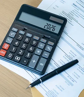 Calculator on the table with a pen and paper
