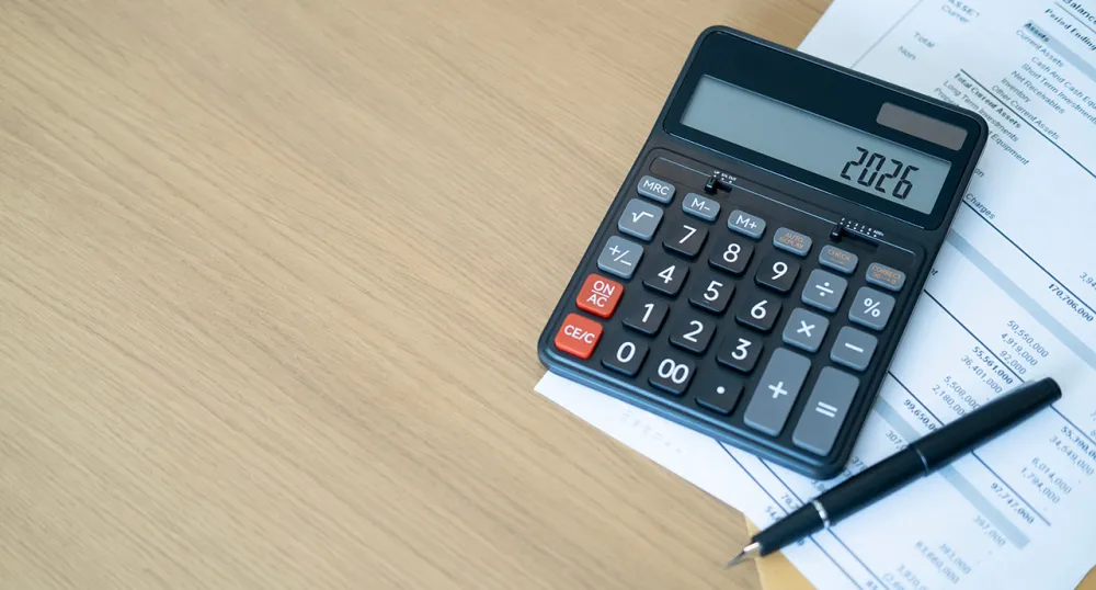 Calculator on the table with a pen and paper