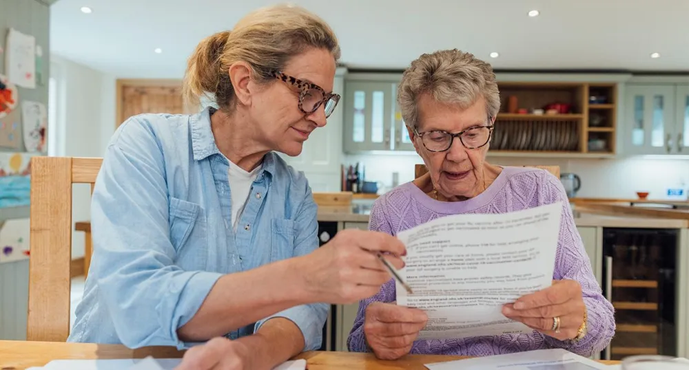 Daughter helping her mother with retirement paperwork
