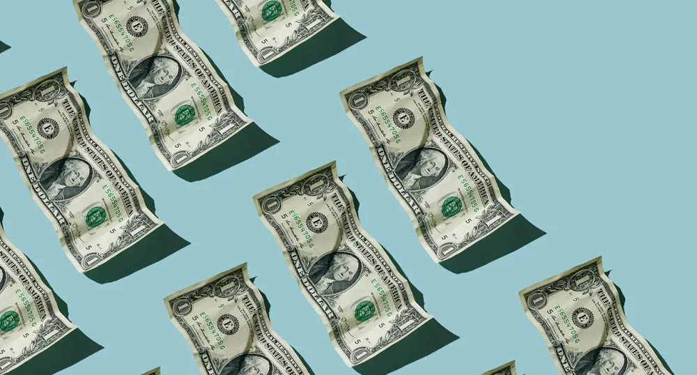 Wrinkled one dollar bills stacked in rows