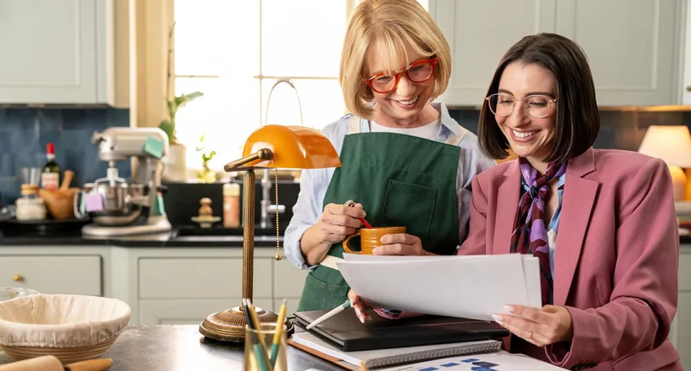 Elderly woman in her kitchen speaking with her financial advisor