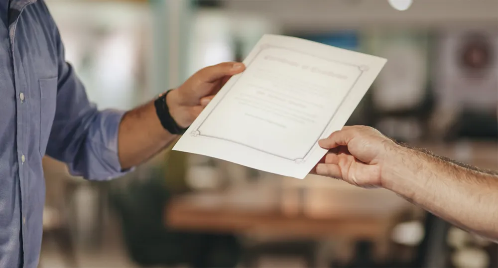 Man being handed his proof of certification